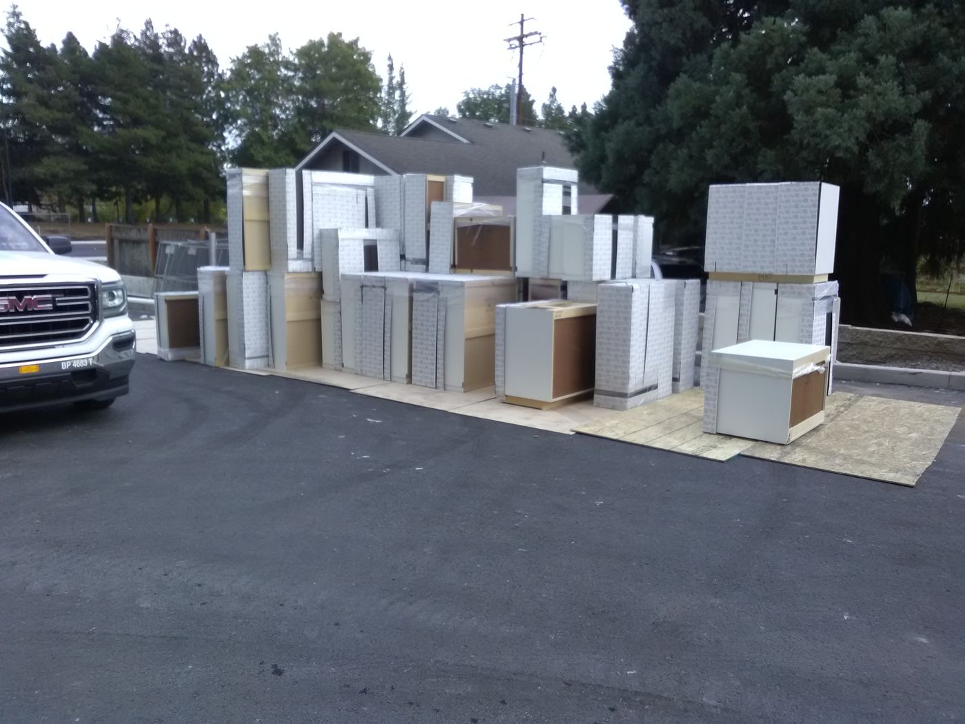 Rows of new cabinets staged in a parking lot for a commercial delivery